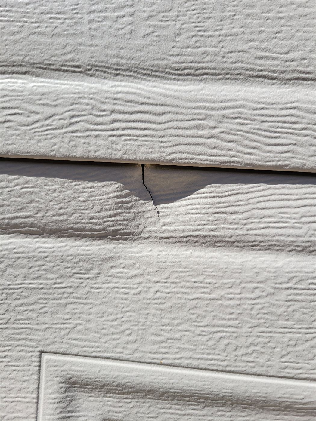 Before photo of a cracked garage door panel for a property manager