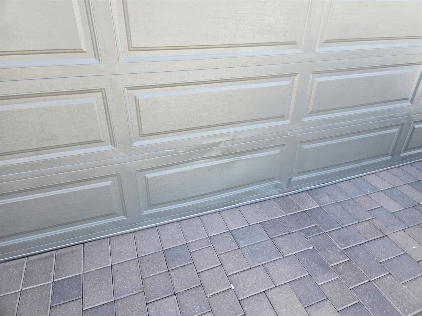 Damaged garage door section before a matching panel was ordered