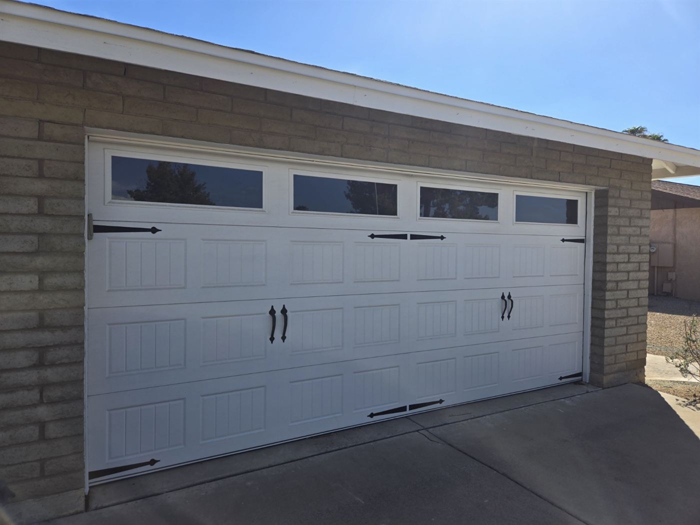 New carriage-style garage door with windows and decorative hardware