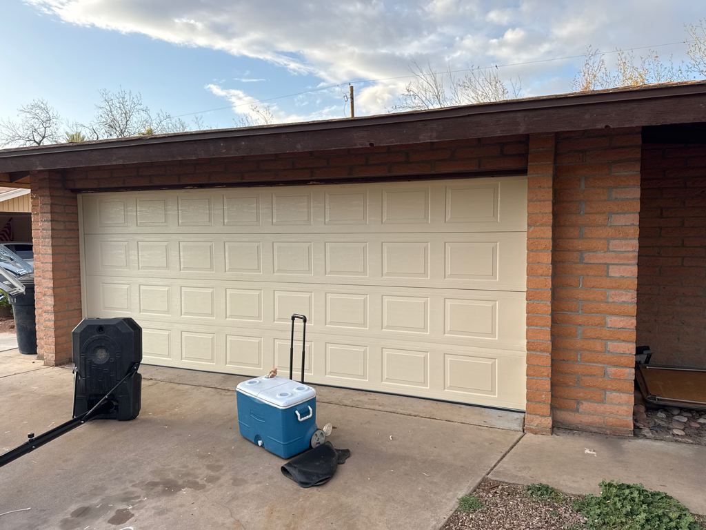 New raised-panel garage door on a brick home