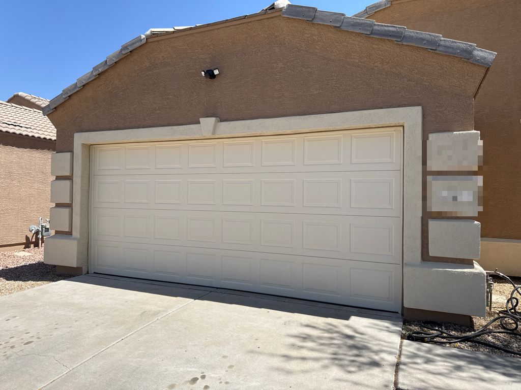 New raised-panel garage door on a stucco home with a tile roof