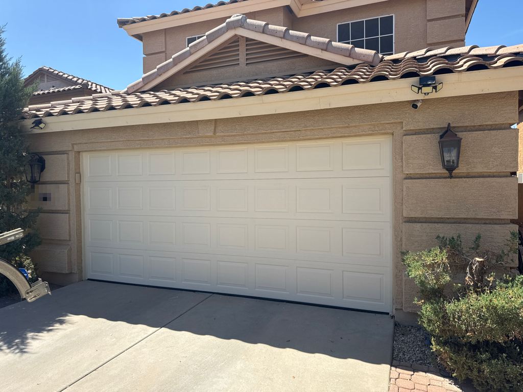New raised-panel garage door on a two-story stucco home